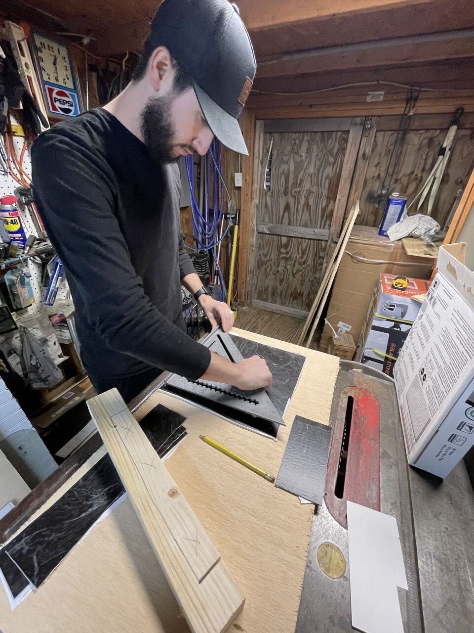 Man working in shed on measuring vinyl tiles