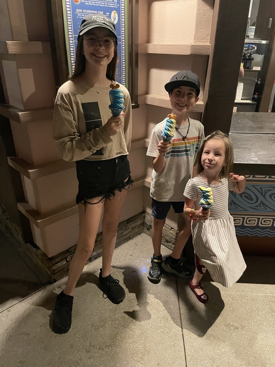 Kids with their blue dole whip with Mickey Mouse cookies at Disney Springs